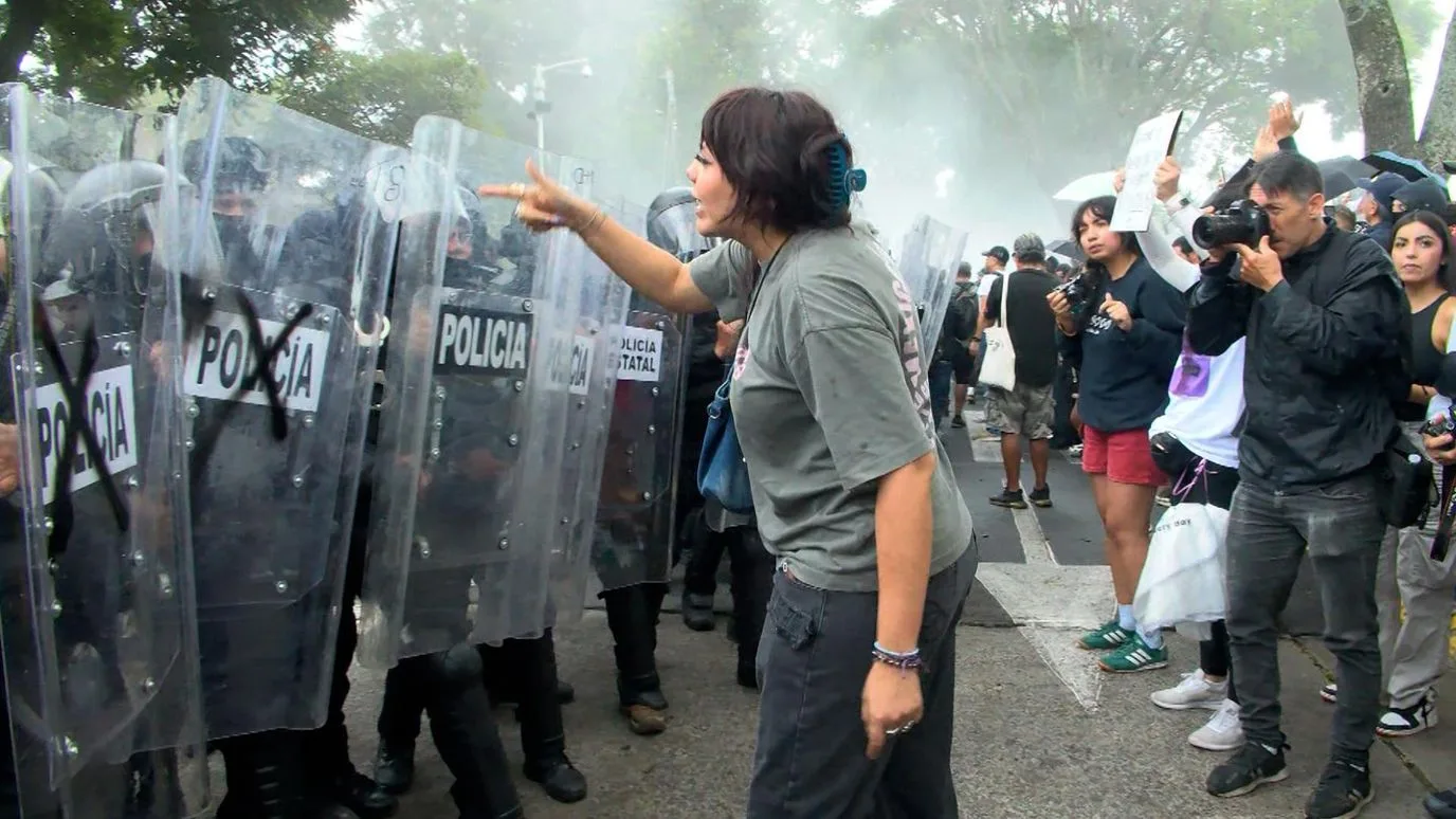 Manifestantes frente a policías durante la protesta por agua limpia en Guadalajara