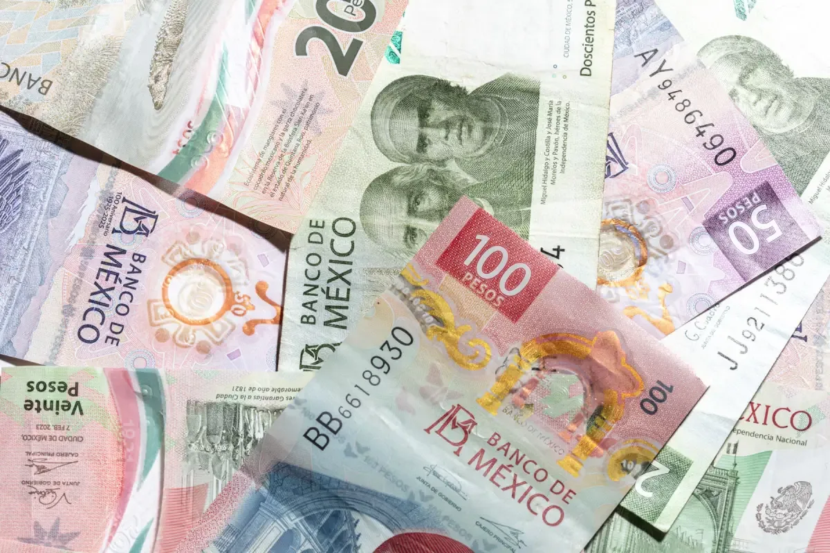 Billetes y monedas mexicanos en una fotografía ilustrativa. El PIB mide la producción agregada; su crecimiento no implica una mejora idéntica del ingreso de todos los hogares.